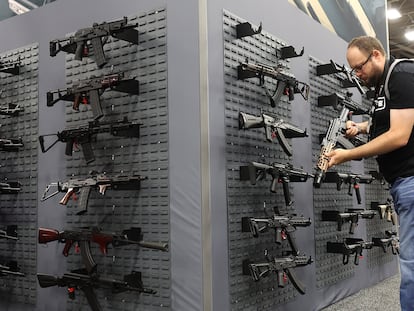 Un asistente a una feria de la Asociación Nacional del Rifle (NRA) en Dallas examina un arma, en una imagen de 2024.
