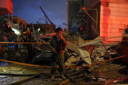 Fuerzas de seguridad inspeccionan los daños causados en varios edificio tras ser alcanzados por misiles lanzados desde Irán en las cercanías de Tel Aviv, este domingo.