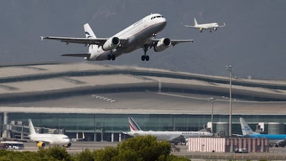 En la imagen, un avión despega mientras otro aterriza en el aeropuerto de Barcelona.